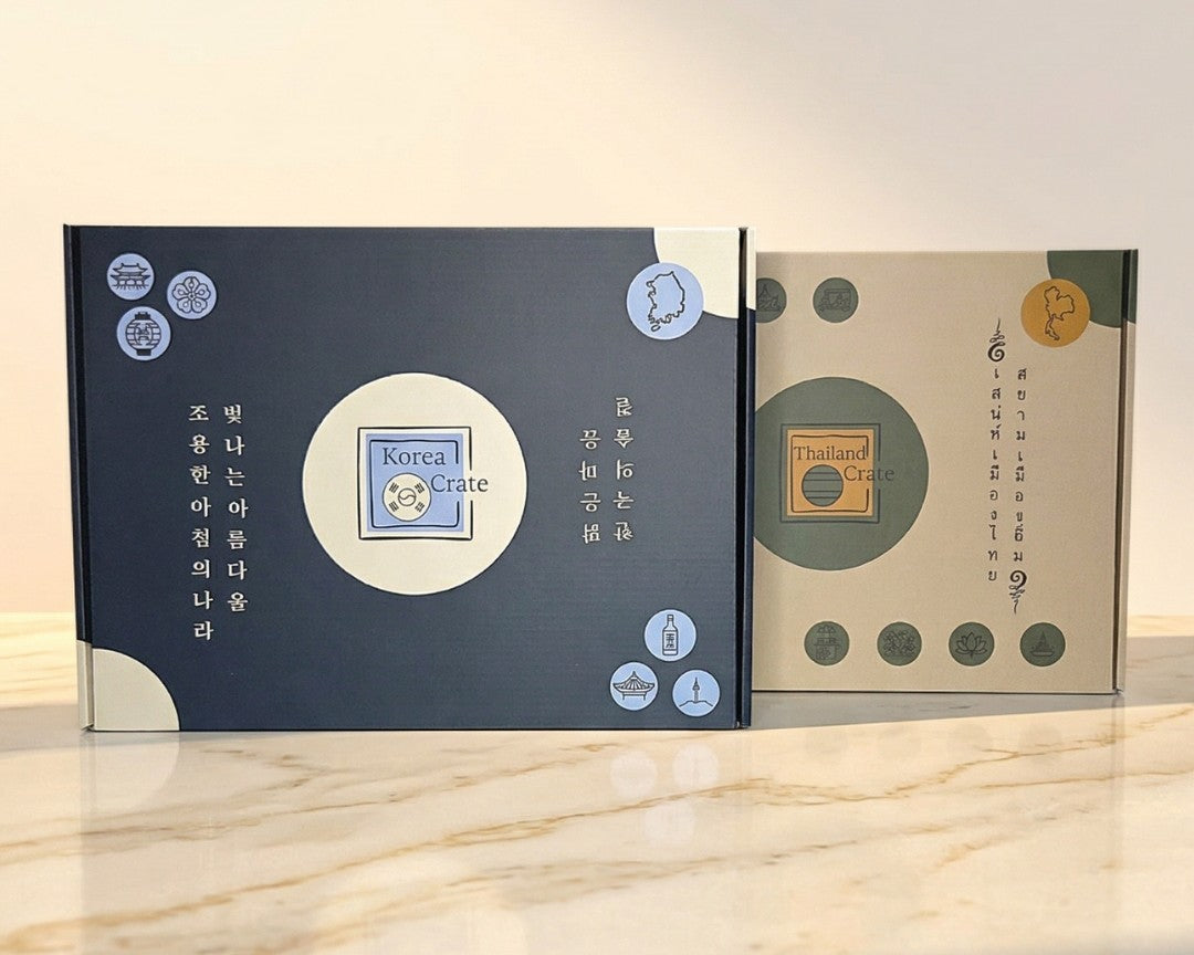 Oversea Crate Länderboxen im Vergleich: Thailand Geschenkbox und Korea Skincare Box nebeneinander als kulturelles Erlebnis für Zuhause.