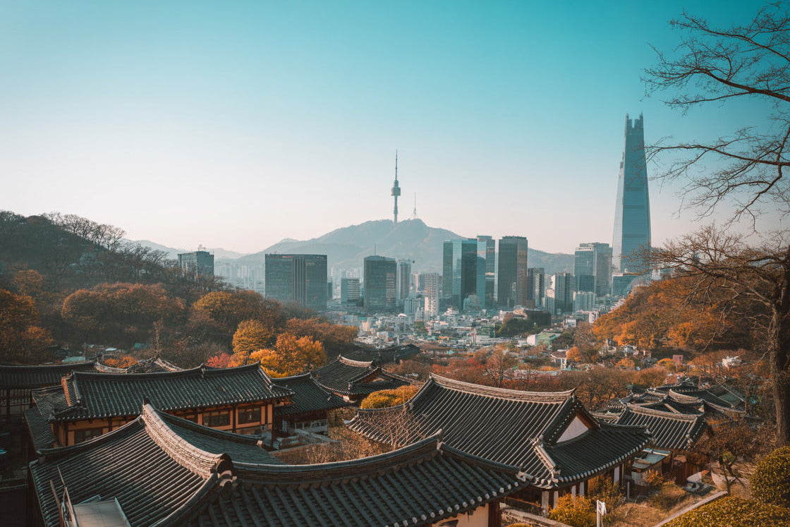 Weitläufiges Panorama über die traditionellen Ziegeldächer Seouls hinweg auf den N Seoul Tower und die moderne Skyline – entdecke die architektonische Vielfalt mit der Korea Erlebnisbox von Oversea Crate.